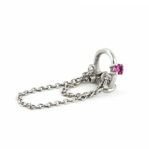 18k white gold clip with ruby and chains hanging on the side of the ear.